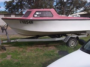 OLD MOTOR BOAT ON UNREGISTERED TRAILER, SOME WORK NEEDED.